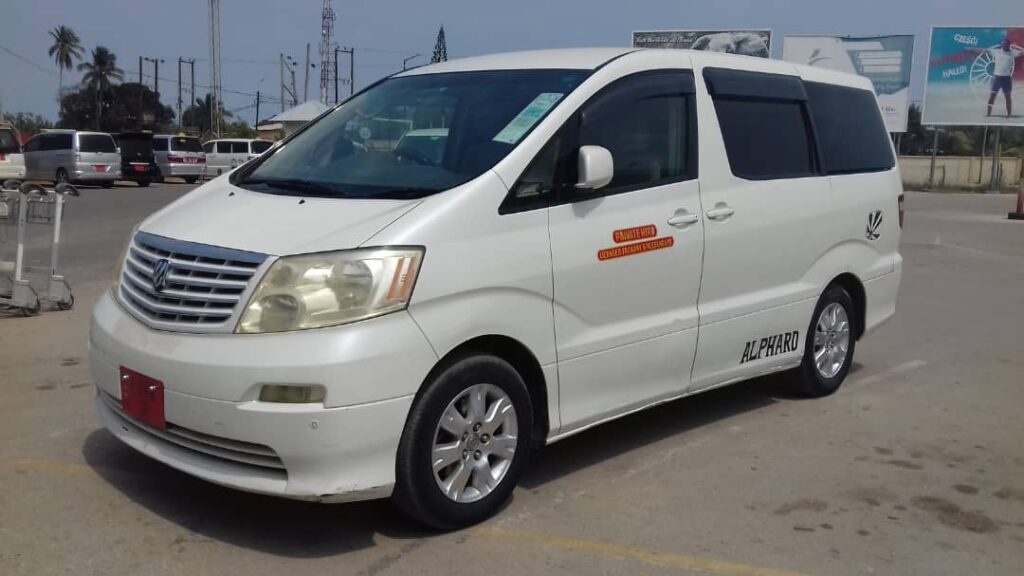 White Toyota Alphard transfer vehicle by Kai Tours and Safaris parked at Zanzibar airport